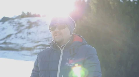 Young attractive man in sunglasses standing near tree among the Alps. Stock Footage 62849294