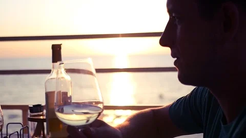 Young attractive man is talking over a glass of wine against the background of Stock Footage 79782192