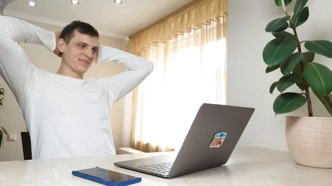 Young attractive man is typing something on a laptop, then leans back Stock-Footage 126104585