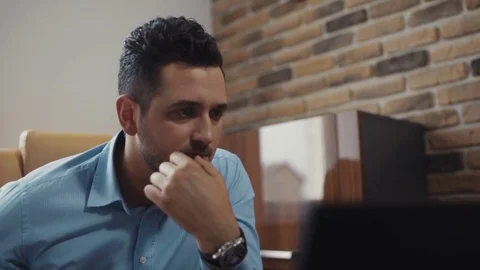 Young attractive man uses a laptop working in the office. Business. Surprised Stock Footage