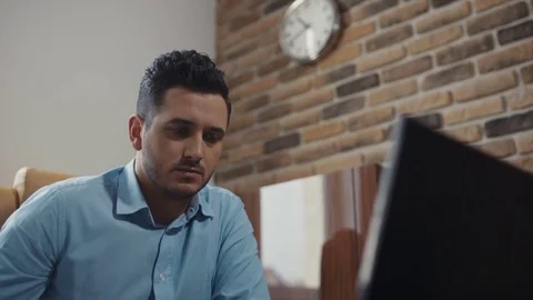Young attractive man uses a laptop working in the office. Business. Speaks by Stock Footage