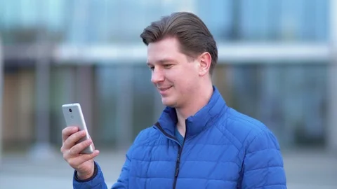 A young attractive man is using a mobile phone at sunset. Stock Footage 88170323