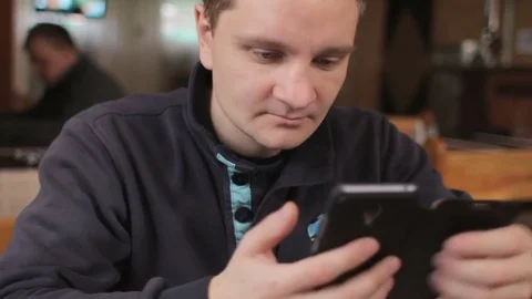 Young attractive man using smart phone in cafe Stock Footage 74434429