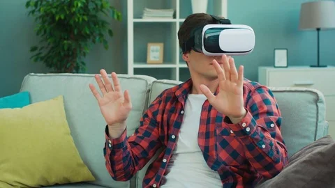 Young attractive man using virtual reality headset for entertainment and Stock Footage 75550749