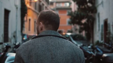 Young attractive man walking in the side street. Male turns, looks around and Stock Footage