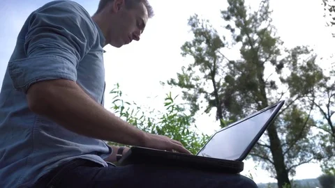 Young attractive man working on computer in the park 動画素材 70132648