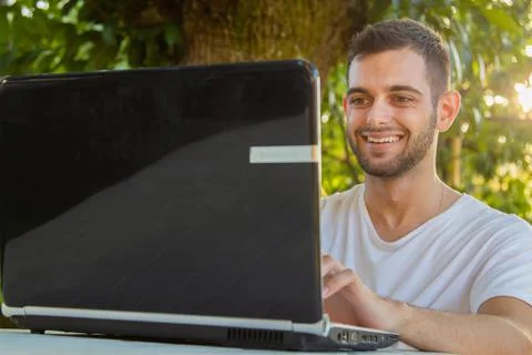 Young attractive man working with computer outdoors Stock Photos