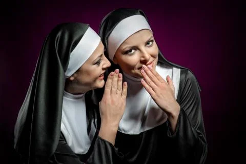 Young attractive nun whispering a secret to another nun Stock Photos
