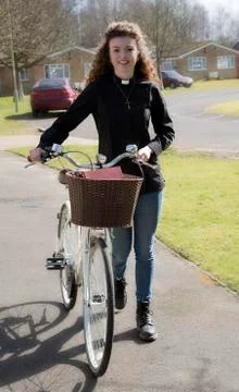 Young attractive parish priest using a bicycle as transport Stock Photos