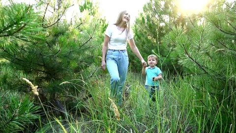 Young attractive sister having nice relaxing walk with little brother in pine Stock Footage 104220663