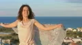 Young attractive woman dancing with scarf, enjoying vacation at seaside resort 4k or 4k+ Resolution