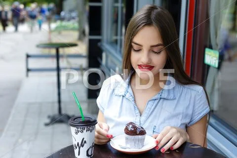 Young Attractive Woman Eating Cake With Coffee In Outdoor Cafe