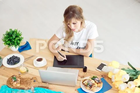 Young attractive woman freelancer sitting front laptop computer drawing on Stock Photos