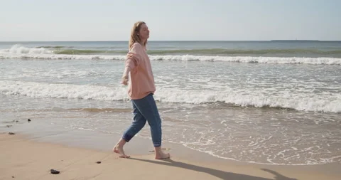Young attractive woman having fun at the beach barefoot smiling turning around Stock Footage 133456653