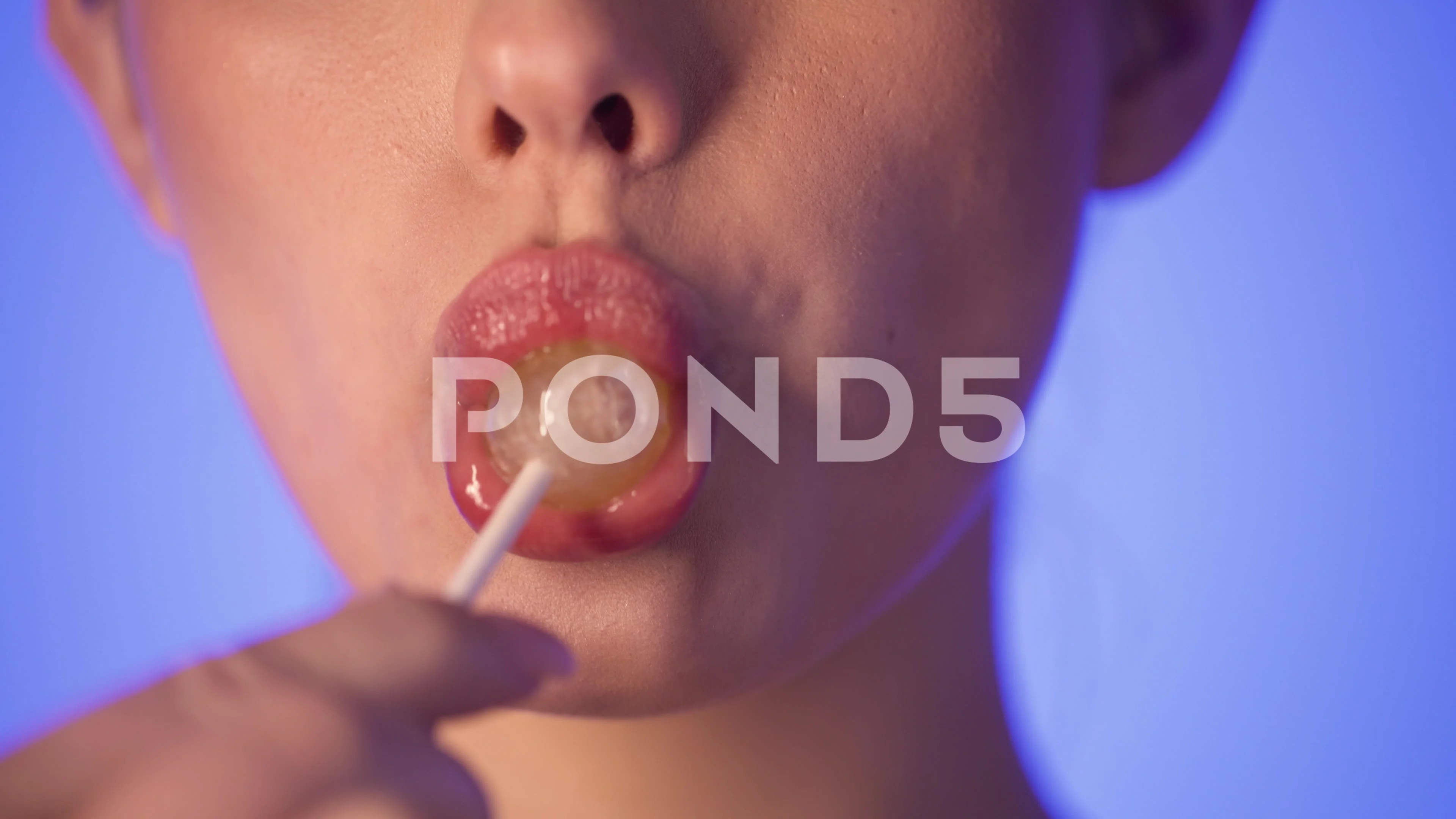 Young attractive woman licking a lollipop, close-up lips, sensual, studio