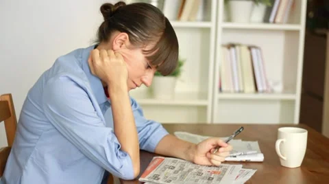 Young attractive woman looking in newspaper for job HD Stock Footage