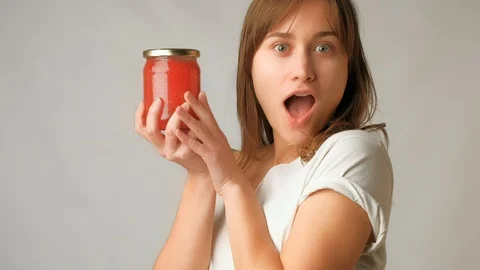 Young attractive woman showing surprisingly jar of red caviar in excitment Stock Footage
