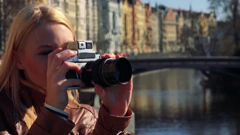 A young attractive woman takes photos, then smiles at the camera - face closeup Stock Footage