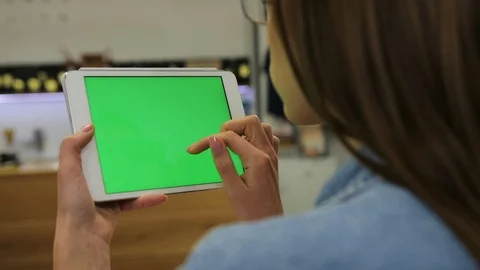 Young attractive woman using tablet with green screen sitting in the cafe, swipe Stock Footage 72361374