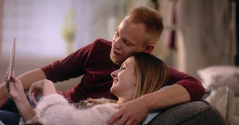 Young attraktive couple is using digital tablet at home Video stock 77407076