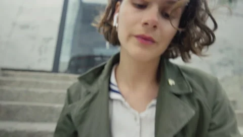 Young authentic woman insert ear buds for music Stock Footage 161060456