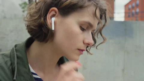Young authentic woman insert ear buds for music Stock Footage 170855756