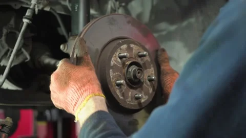 Young auto mechanic repairs an old car. brake disc installation. Stock Footage 211811247