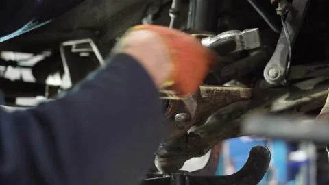 Young auto mechanic repairs an old car. dismantling of old parts. Stock Footage 215788280