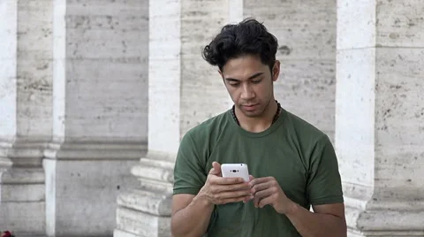 Young awesome man using the touchscreen of a smartphone in the city Video stock 66680380