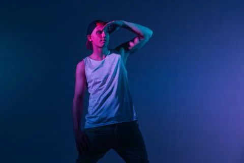 Young b-boy dancer posing in Studio with colored light. Stock Photos