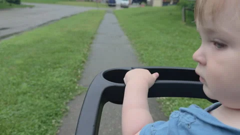 Young baby boy riding in stroller on sidewalk 4k Stock Footage 342372801