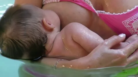 Young baby sucking milk from mother's br... | Stock Video