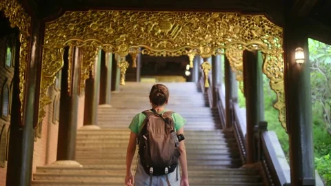 A young backpacker woman with camera exploring a temple in Asia Vídeos de archivo 248513970