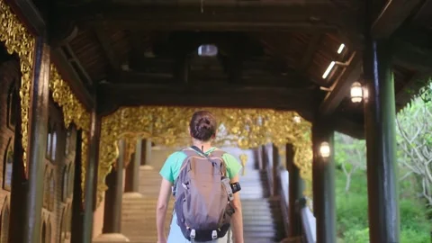 A young backpacker woman with camera exploring a temple in Asia Stock Footage 248513972
