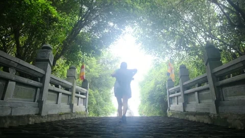 A young backpacker woman with camera exploring a temple in Asia Stock Footage 248514058