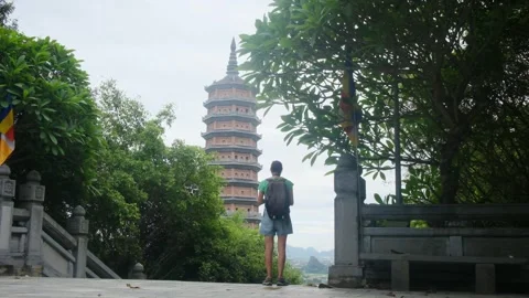 A young backpacker woman with camera exploring a temple in Asia Stock Footage 248514087