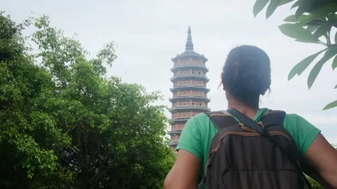 A young backpacker woman with camera exploring a temple in Asia Stock Footage 248514477