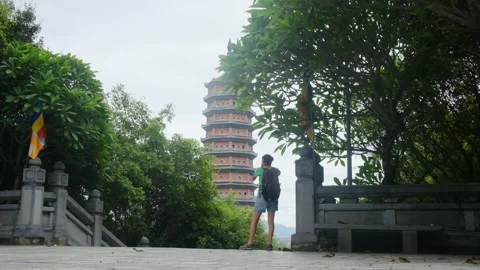 A young backpacker woman with camera exploring a temple in Asia Stock Footage 248514507
