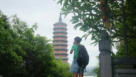A young backpacker woman with camera exploring a temple in Asia Stock Footage 248514539