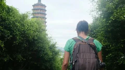 A young backpacker woman with camera exploring a temple in Asia Vídeos de archivo 248515341
