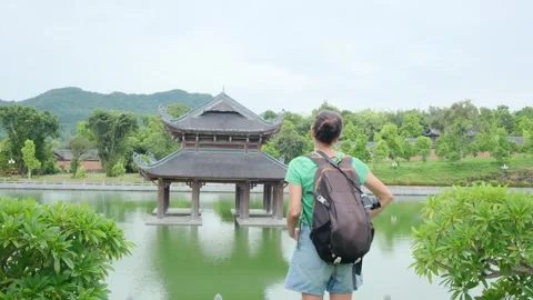 A young backpacker woman with camera exploring a temple in Asia Stock Footage 248515965