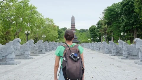 A young backpacker woman with camera exploring a temple in Asia Stock Footage 248515976