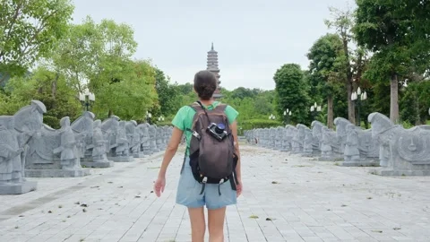A young backpacker woman with camera exploring a temple in Asia Stock Footage 248515999