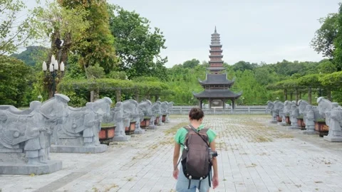 A young backpacker woman with camera exploring a temple in Asia Stock Footage 248516042
