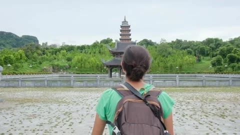 A young backpacker woman with camera exploring a temple in Asia Stock Footage 248516098