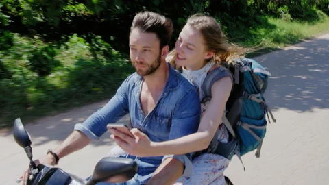 Young backpacking couple having a road trip together on hired Scooter in Thailan Vídeos de archivo 199476116