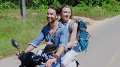 Young backpacking couple having a road trip together on hired Scooter in Thailan Stock Footage 201093913