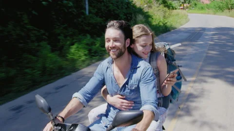 Young backpacking couple having a road trip together on hired Scooter in Thailan Stock Footage 201096821