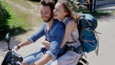 Young backpacking holiday couple having a road trip together on hired Scooter in Vídeos de archivo 201094179