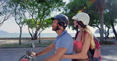 Young backpacking holiday couple having a road trip together on hired Scooter in Stock Footage 201094268